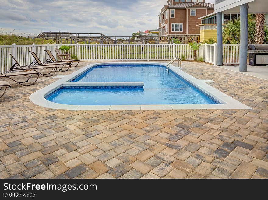 A blue swimming pool on the yard of a house. A blue swimming pool on the yard of a house.