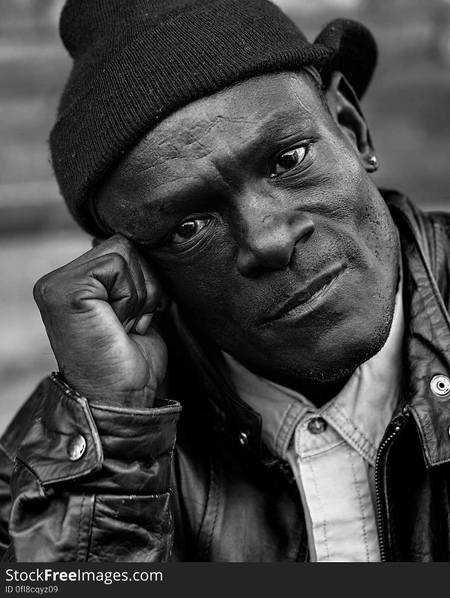 Close up portrait of African man in leather jacket and knit beanie in black and white. Close up portrait of African man in leather jacket and knit beanie in black and white.