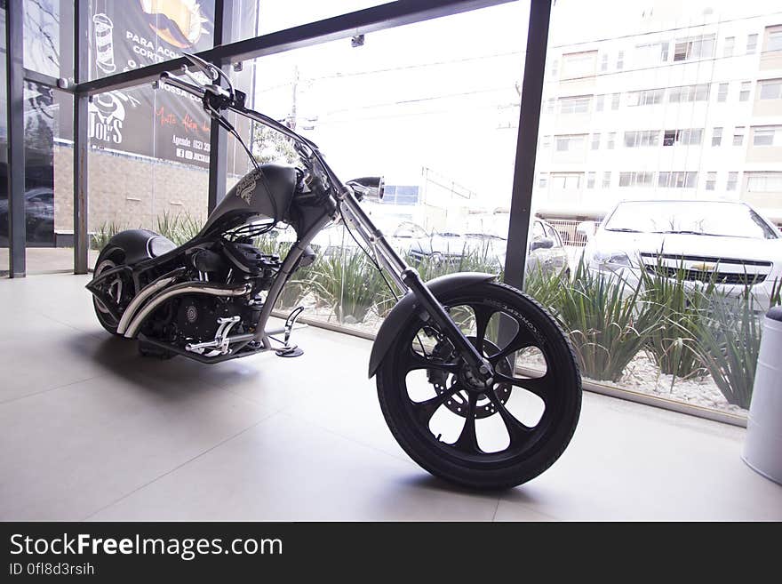 Modern motorbike inside showroom against window in city. Modern motorbike inside showroom against window in city.