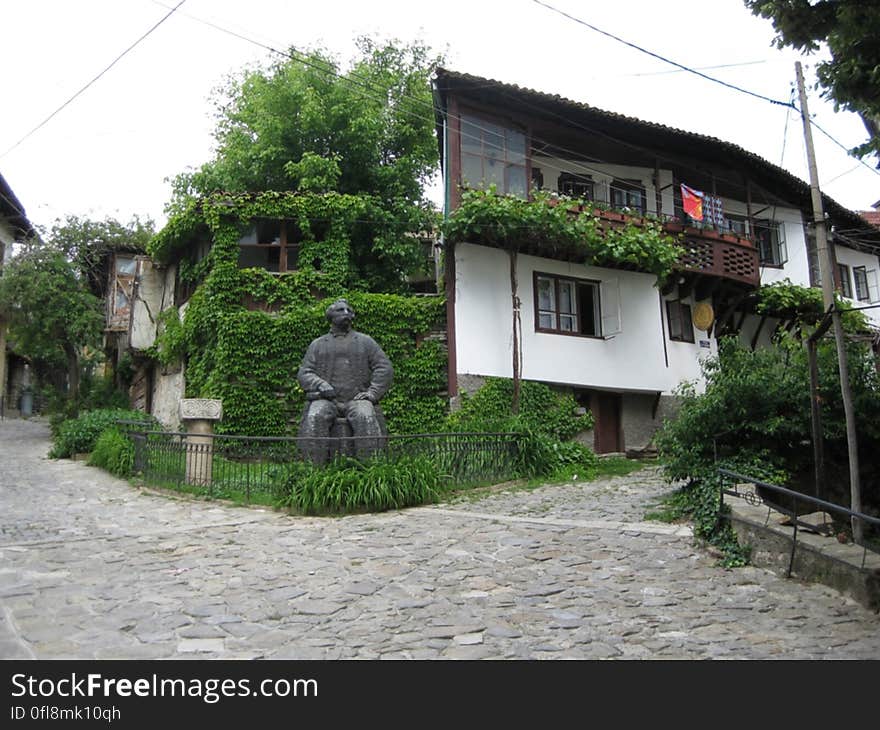 A house in traditional style and a statue in the garden. A house in traditional style and a statue in the garden.