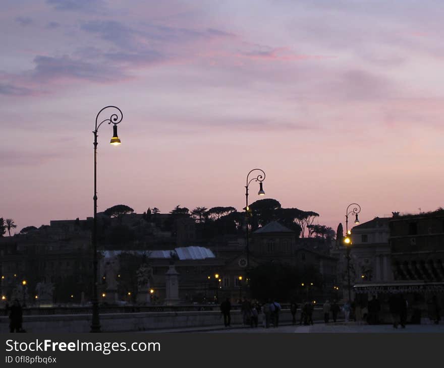 A view of a city with sun setting in the horizon. A view of a city with sun setting in the horizon.