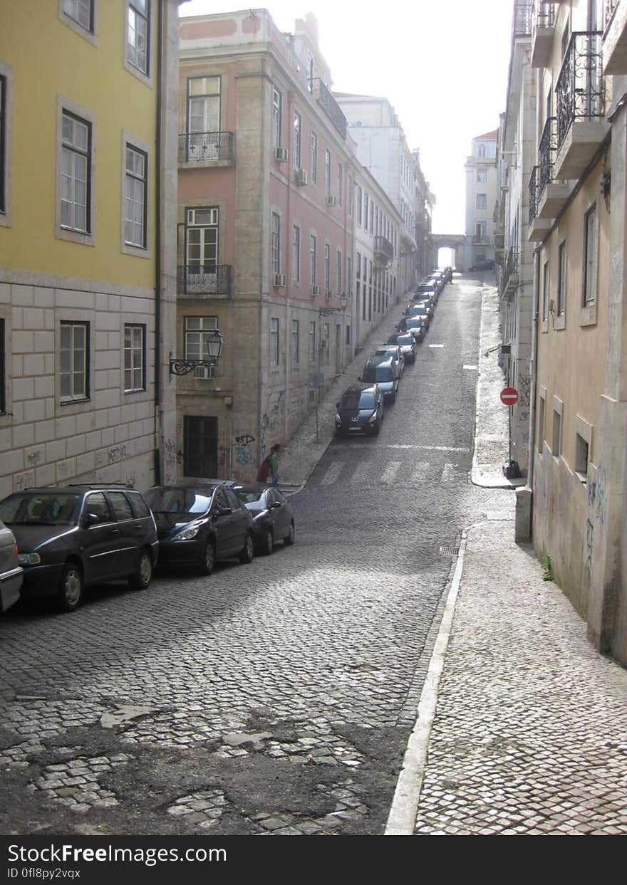 A view of a street with cars parked to the side. A view of a street with cars parked to the side.