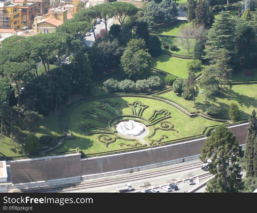 A green garden with topiary and fountain.