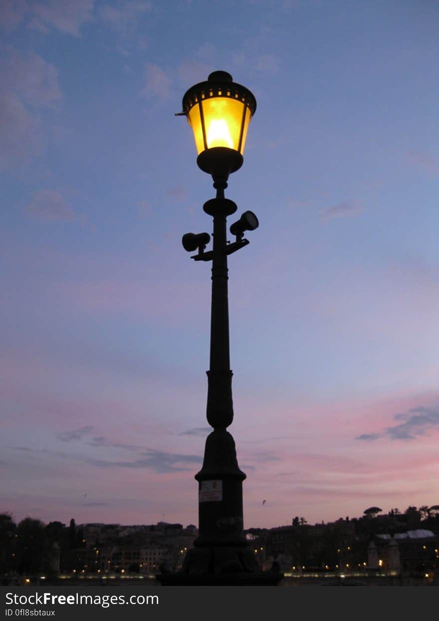 A street lamp with the light on at night. A street lamp with the light on at night.