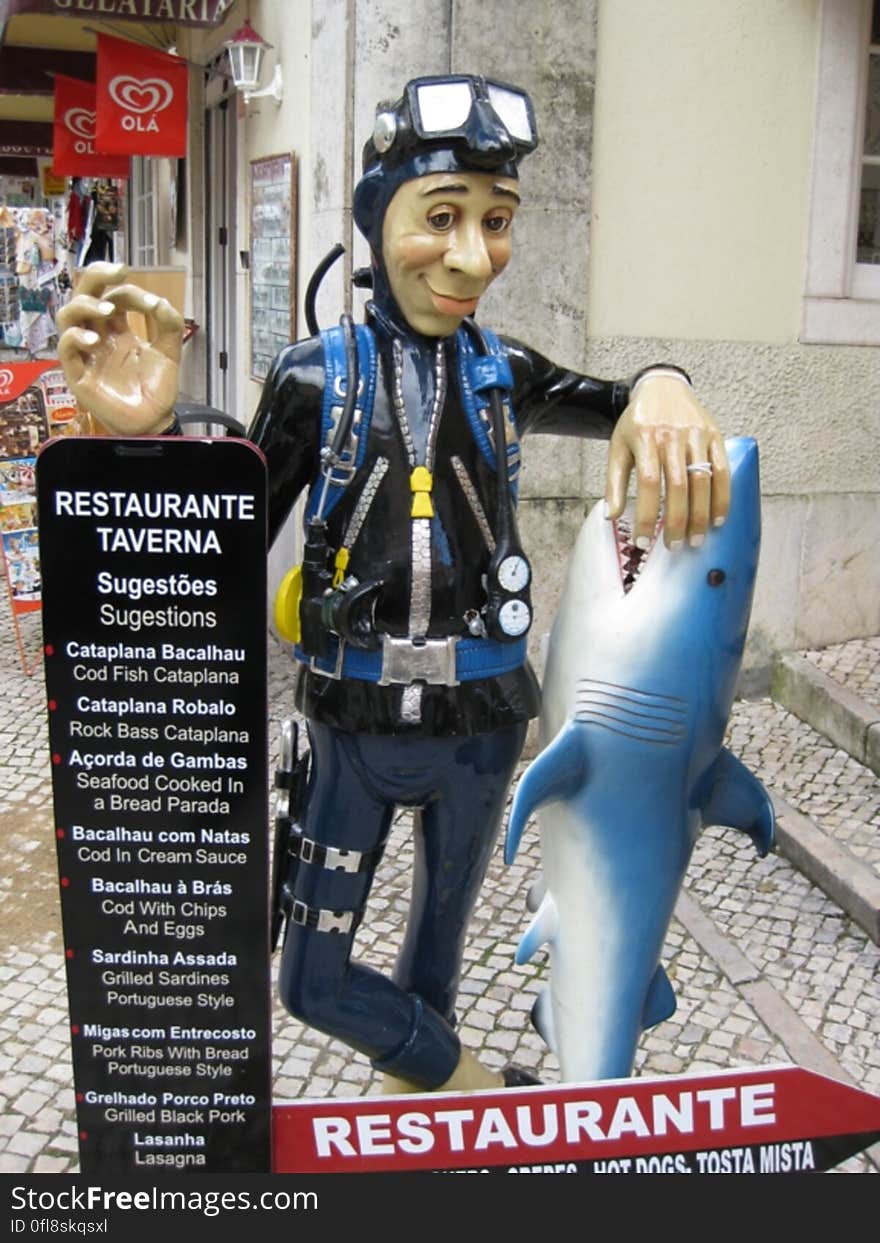 The sign of a seafood restaurant with a diver and a shark. The sign of a seafood restaurant with a diver and a shark.