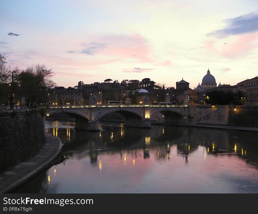 A view of a river in a city at sunset. A view of a river in a city at sunset.