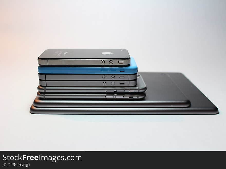 Different models of iPhone piled up on a white background. Different models of iPhone piled up on a white background.