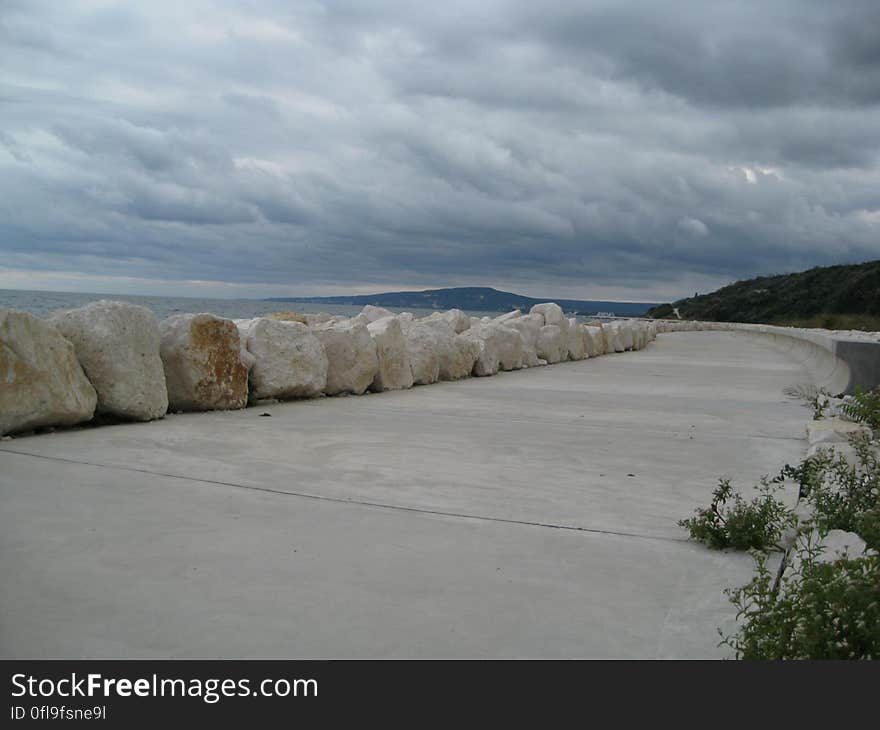 An empty promenade by the sea and rocks aside. An empty promenade by the sea and rocks aside.