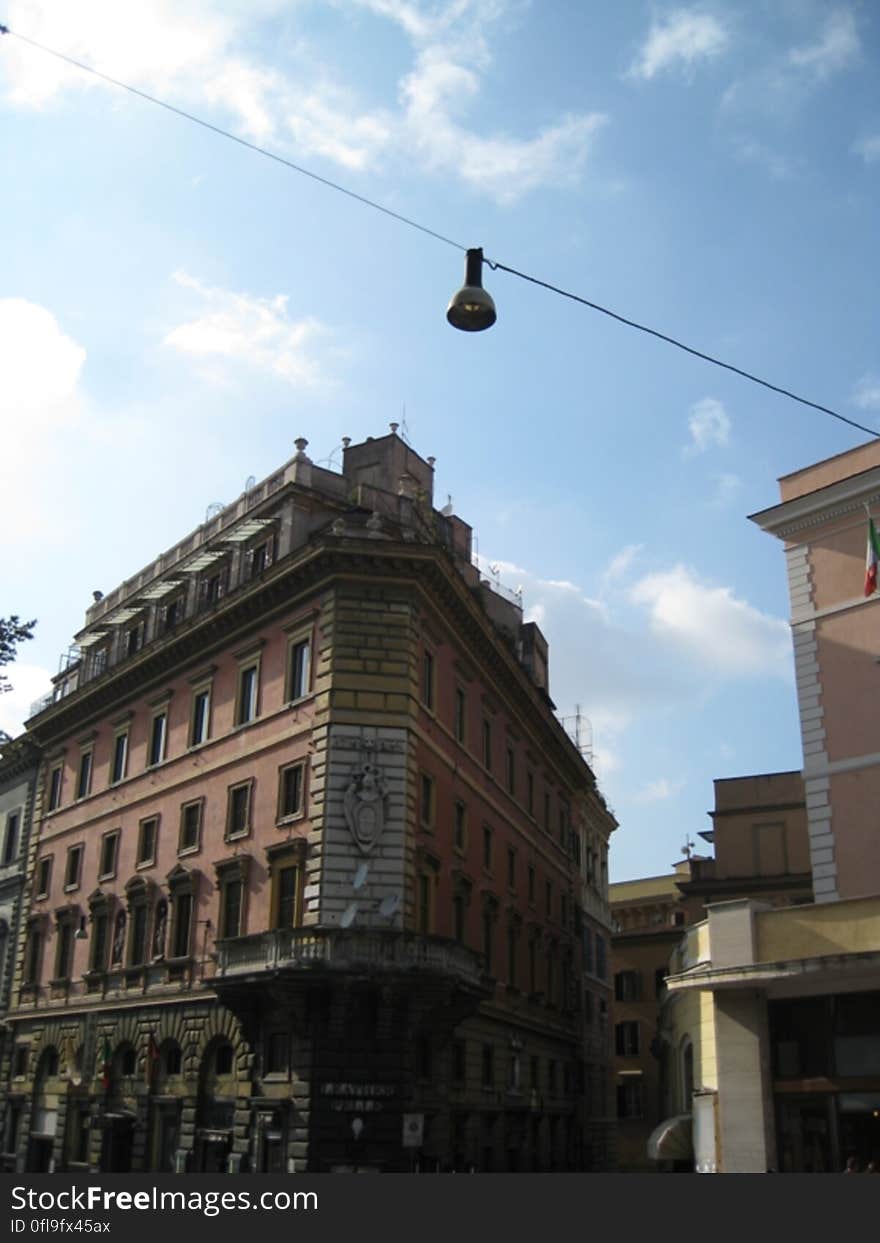 A historic building and a street lamp hanging on a cable stretched above the street. A historic building and a street lamp hanging on a cable stretched above the street.