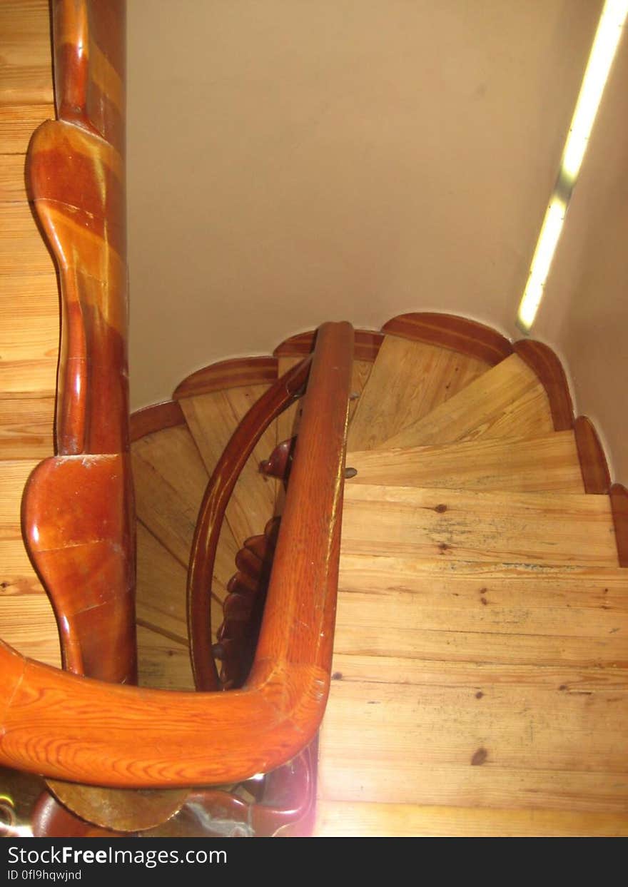 View looking down a curved wooden staircase in a home.