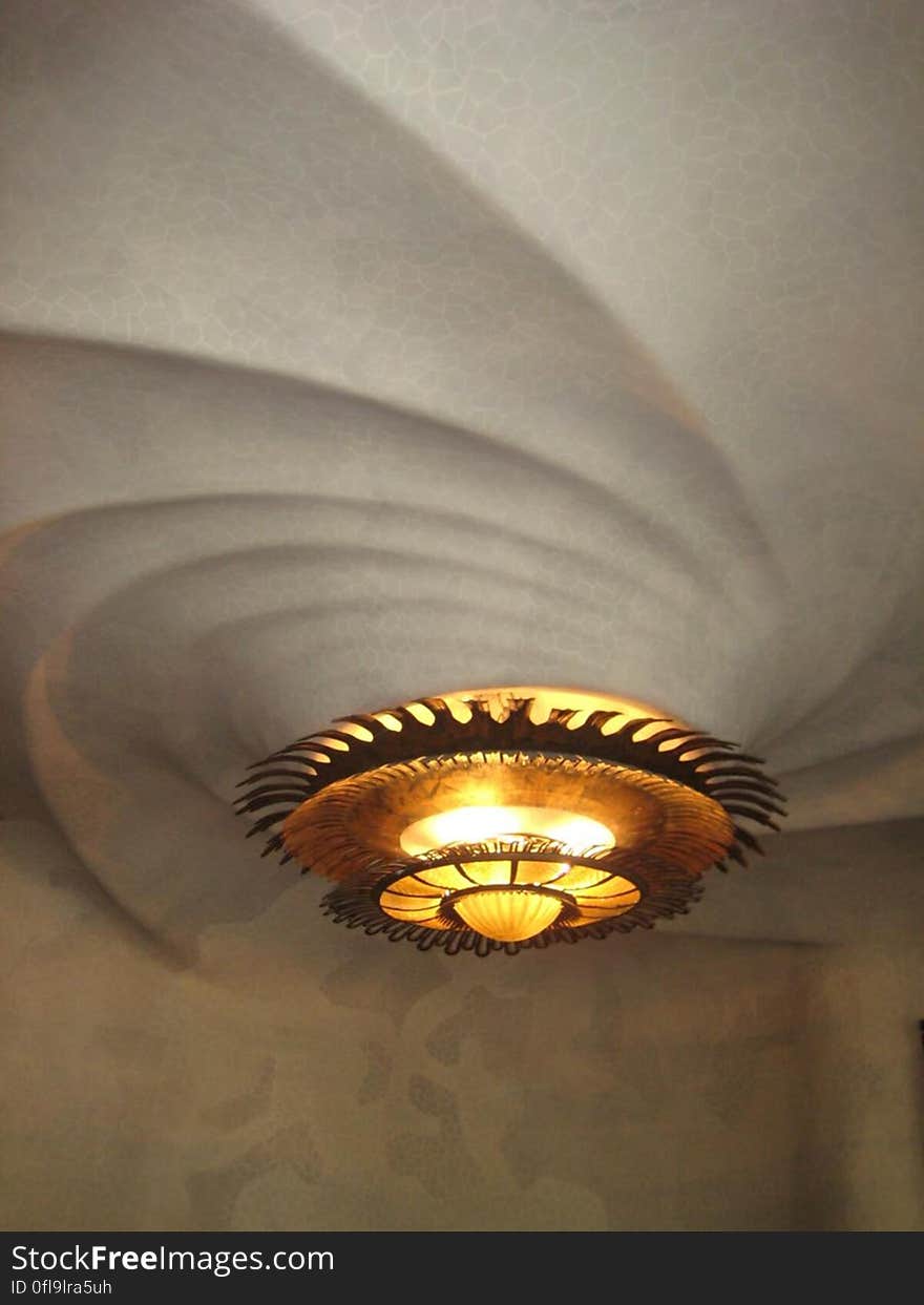 A luxurious round chandelier on ceiling relief. A luxurious round chandelier on ceiling relief.