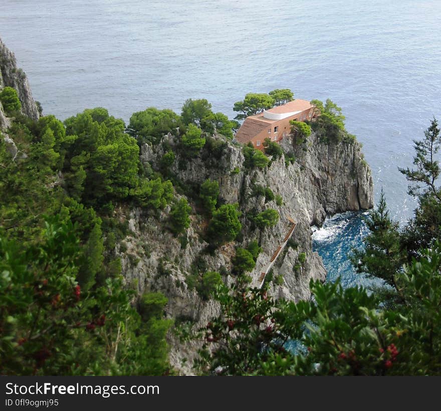 A view of a house on a sea cliff and the sea in the background. A view of a house on a sea cliff and the sea in the background.