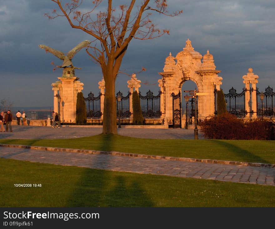 A view of a park with a fence and gates at sunset. A view of a park with a fence and gates at sunset.