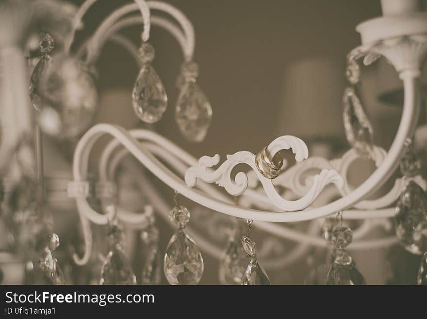 A close up of a crystal chandelier with wedding rings hanging from it. A close up of a crystal chandelier with wedding rings hanging from it.