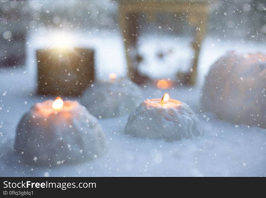 Snow lanterns with lit candles in the winter.