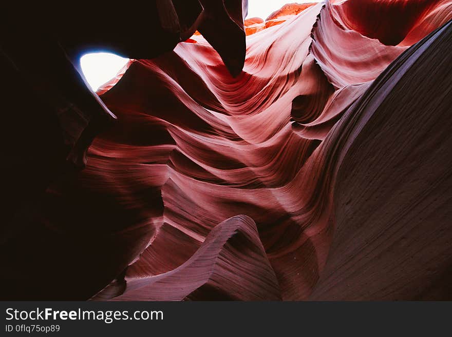 Abstract textured red, white and black background created by light falling unevenly on rocks in a canyon. Abstract textured red, white and black background created by light falling unevenly on rocks in a canyon.