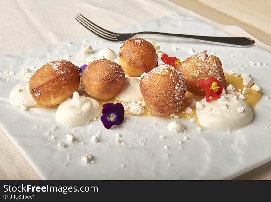 A close up of sweet dough balls on a plate.