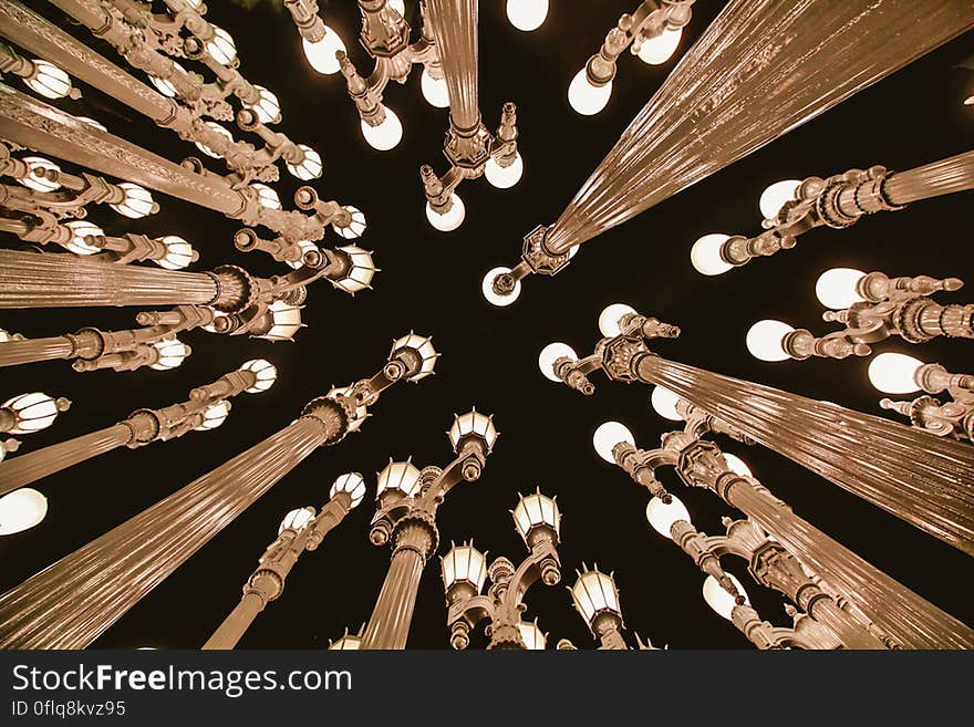 Poles with lightbulbs on top from low angle.