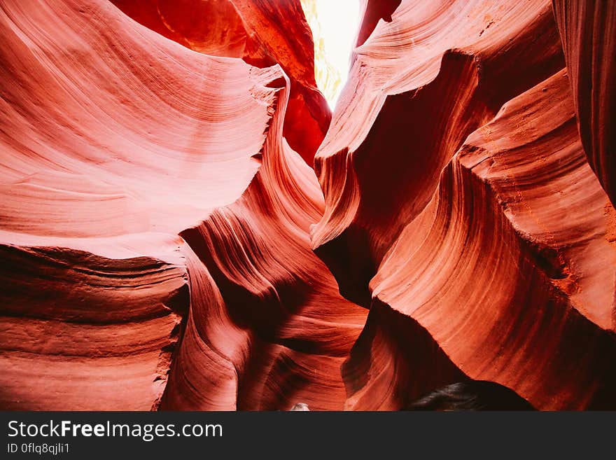 Abstract textured background created by red rocks in ancient canyon illuminated by bright sunlight. Abstract textured background created by red rocks in ancient canyon illuminated by bright sunlight.