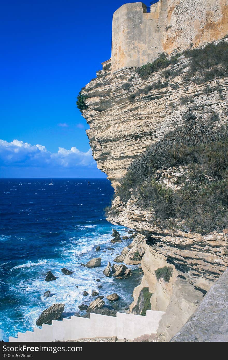 A cliff on the shore of blue sea. A cliff on the shore of blue sea.