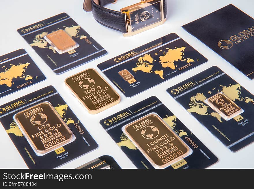 Set of different weight gold bars on decorative blue cars with world map.