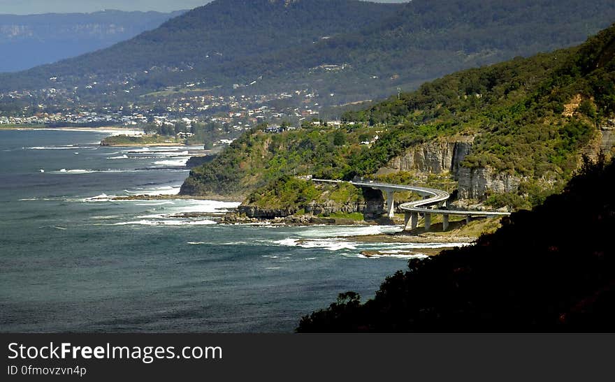 The Sea Cliff Bridge is a balanced cantilever bridge located in the northern Illawarra region of New South Wales, Australia. The $52 million bridge links the coastal villages of Coalcliff and Clifton. Featuring two lanes of traffic, a cycleway and a walkway, the Sea Cliff Bridge boasts spectacular views and is a feature of the scenic Lawrence Hargrave Drive. The Sea Cliff Bridge replaced a section of Lawrence Hargrave Drive that was permanently closed in August 2003 due to regular rock falls. A public outcry emerged over the road closure as Lawrence Hargrave Drive is the only road directly linking Coalcliff, Stanwell Park, Otford and Helensburgh to the northern suburbs of Wollongong. The bridge was officially opened by NSW Premier Morris Iemma at a &#x27;ribbon cutting&#x27; ceremony on 11 December 2005, and has met with great public approval and increased business for the area&#x27;s tourism industry. The Sea Cliff Bridge was named by 11-year-old schoolgirl Makenzie Russell &#x28;St. Brigids&#x29; following a naming competition opened to local primary school students. It is a popular location for Love padlocks. The Sea Cliff Bridge is one of only seven off-shore parallel to coast bridges in the world. The Sea Cliff Bridge is a balanced cantilever bridge located in the northern Illawarra region of New South Wales, Australia. The $52 million bridge links the coastal villages of Coalcliff and Clifton. Featuring two lanes of traffic, a cycleway and a walkway, the Sea Cliff Bridge boasts spectacular views and is a feature of the scenic Lawrence Hargrave Drive. The Sea Cliff Bridge replaced a section of Lawrence Hargrave Drive that was permanently closed in August 2003 due to regular rock falls. A public outcry emerged over the road closure as Lawrence Hargrave Drive is the only road directly linking Coalcliff, Stanwell Park, Otford and Helensburgh to the northern suburbs of Wollongong. The bridge was officially opened by NSW Premier Morris Iemma at a &#x27;ribbon cutting&#x27; ceremony on 11 December 2005, and has met with great public approval and increased business for the area&#x27;s tourism industry. The Sea Cliff Bridge was named by 11-year-old schoolgirl Makenzie Russell &#x28;St. Brigids&#x29; following a naming competition opened to local primary school students. It is a popular location for Love padlocks. The Sea Cliff Bridge is one of only seven off-shore parallel to coast bridges in the world.