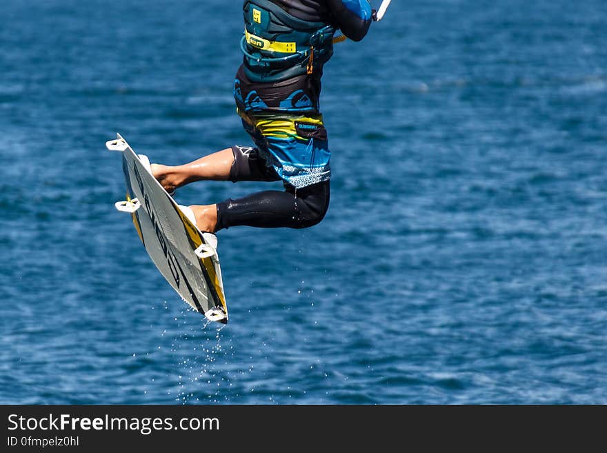 Person in Blue and Black Board Shorts on White Wake Board