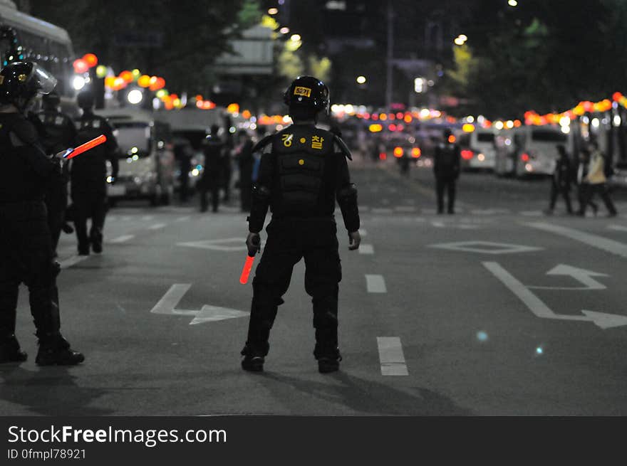 Police officers standing in city streets at night. Police officers standing in city streets at night.