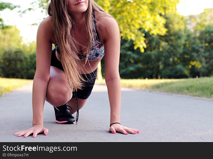 Women&#x27;s Wearing Purple Floral Brassiere Holding Gray Concrete Pathway during Day Time