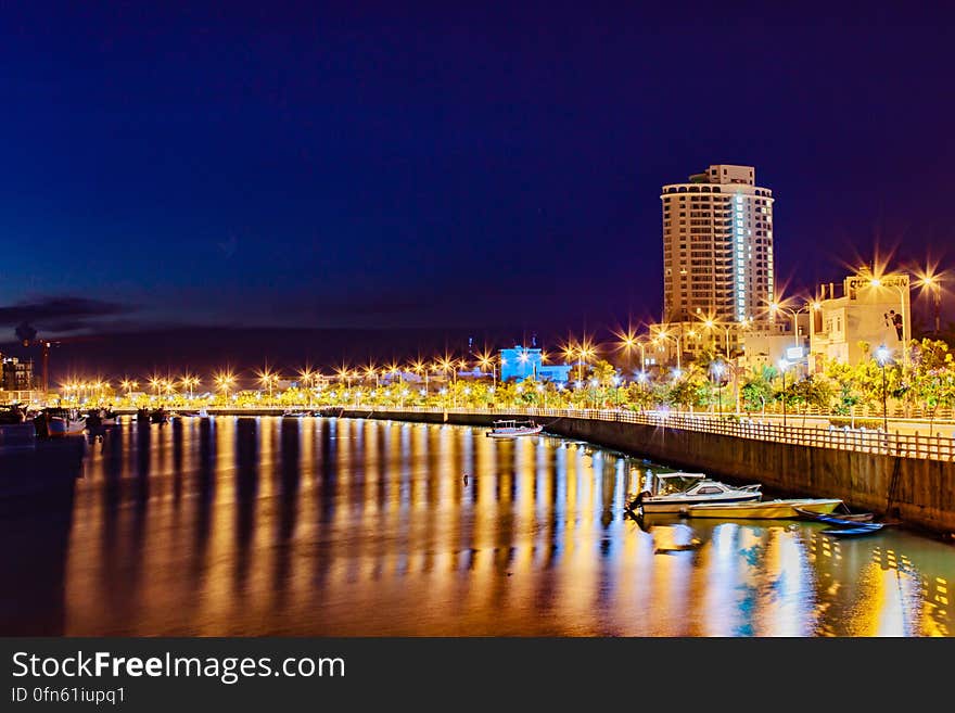 A view of a city with a river passing through it at night. A view of a city with a river passing through it at night.