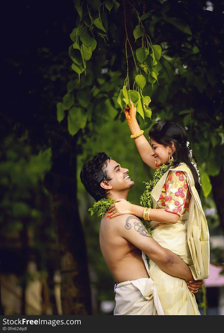 Portrait of young Indian couple embracing outdoors in sunny garden. Portrait of young Indian couple embracing outdoors in sunny garden.