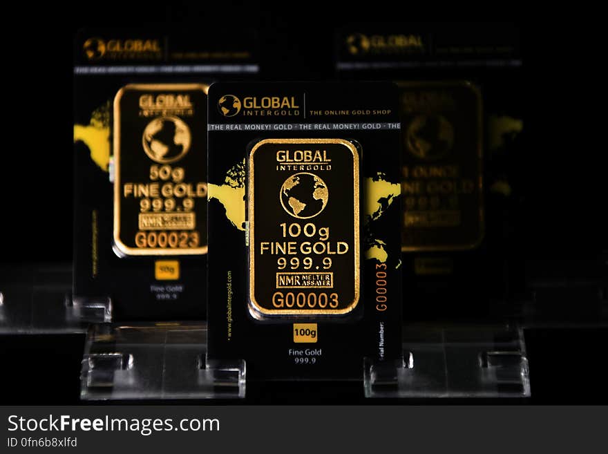 A pair of gold ingots on black background.