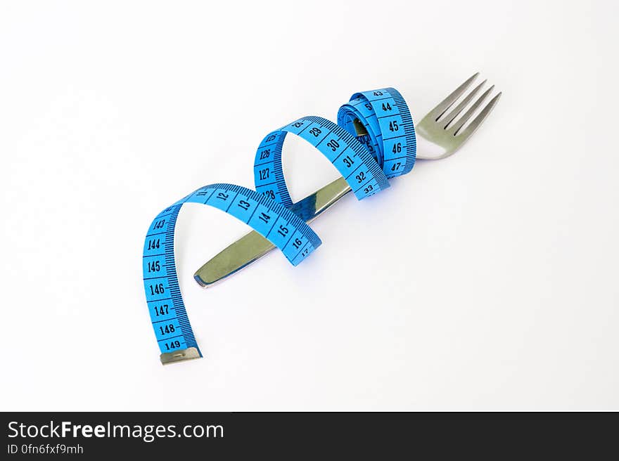 Blue and Black Measuring Tape Wrapped Around a Silver Metal Fork