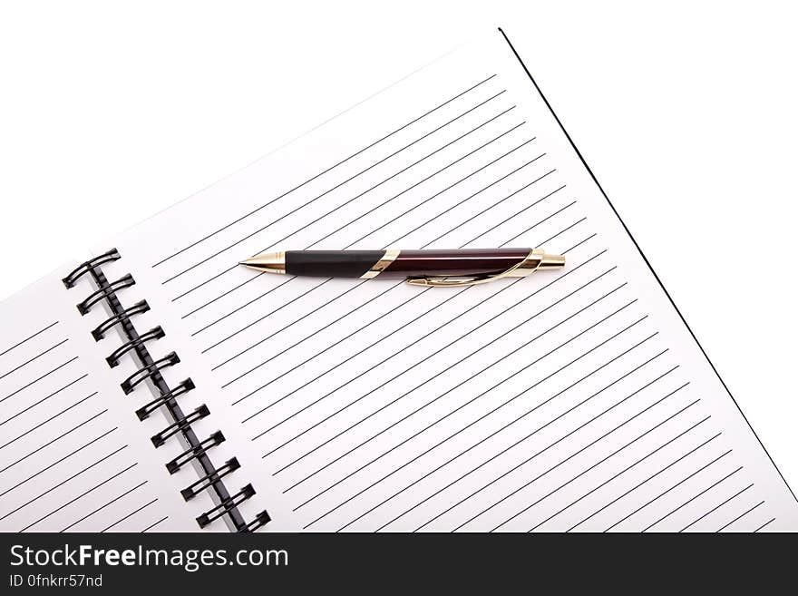 A notebook and a pen on white background. A notebook and a pen on white background.