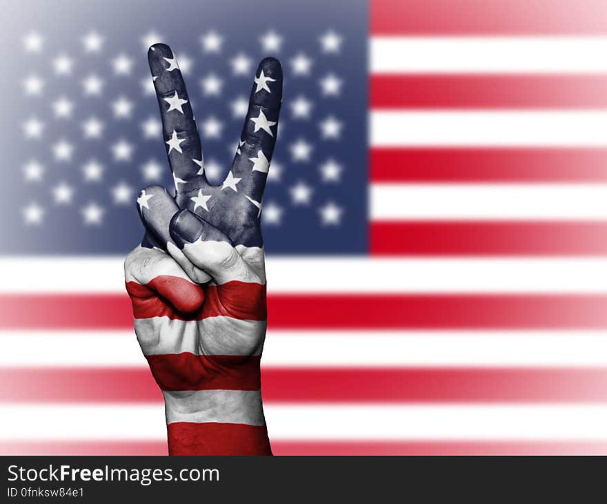 A person doing the V sign in front of the flag of the USA. A person doing the V sign in front of the flag of the USA.