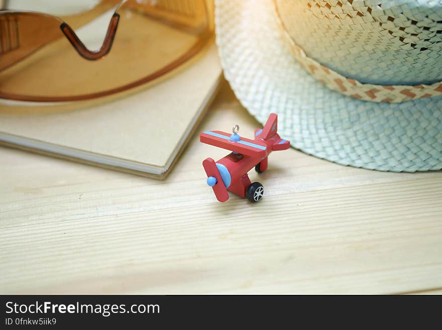 Hat, sunglasses, book and toy airplane on a table. Hat, sunglasses, book and toy airplane on a table.