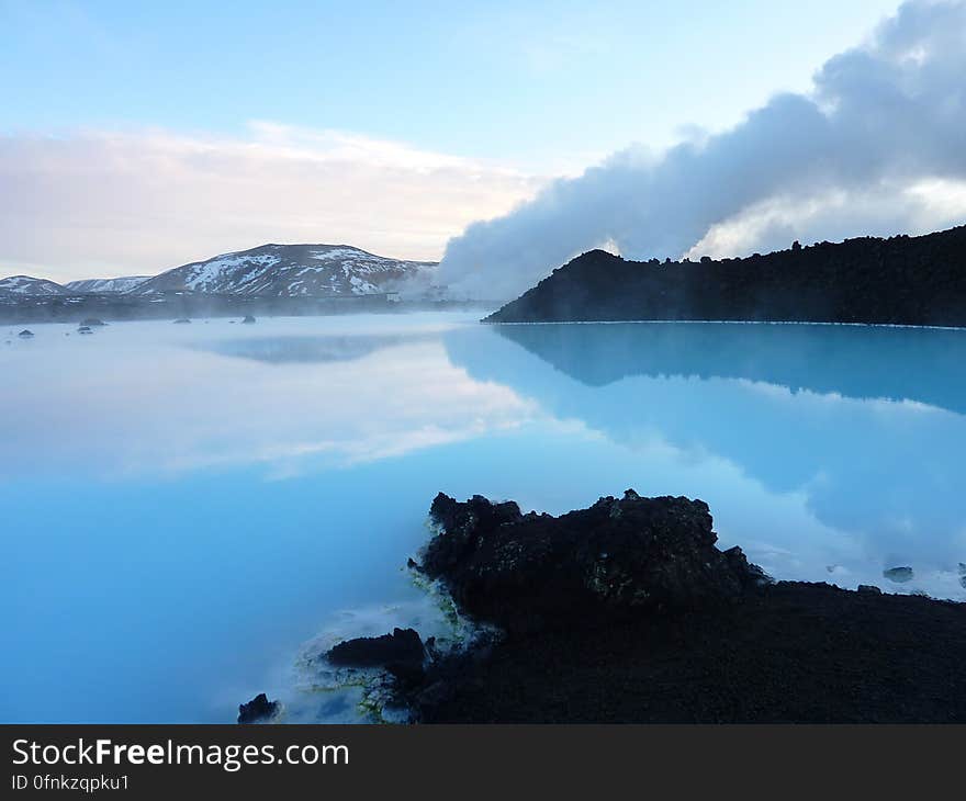 Rocky shoreline along blue waterfront in Iceland on sunny day with blue skies. Rocky shoreline along blue waterfront in Iceland on sunny day with blue skies.