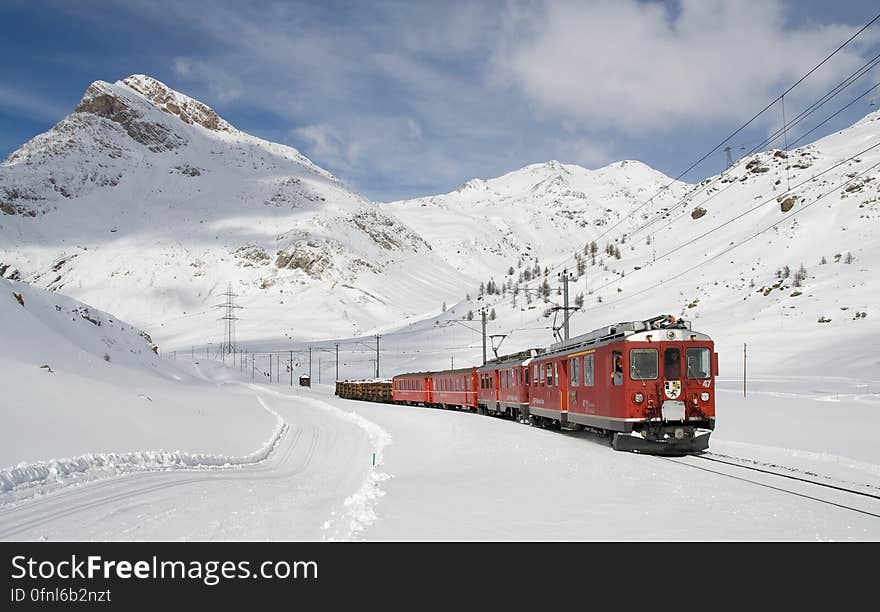 Red and Black Train Running Along Snow Covered Field