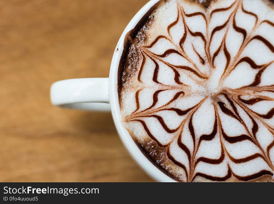 Overhead view of cup of cappuccino with artistic chocolate design. Overhead view of cup of cappuccino with artistic chocolate design.