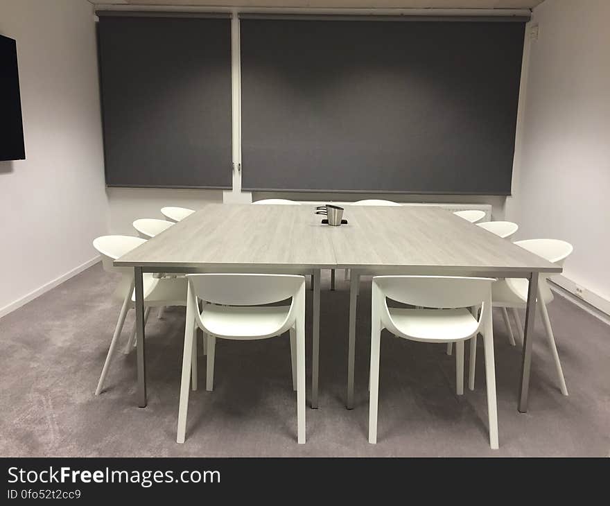 A modern meeting room with table and chairs in the middle.