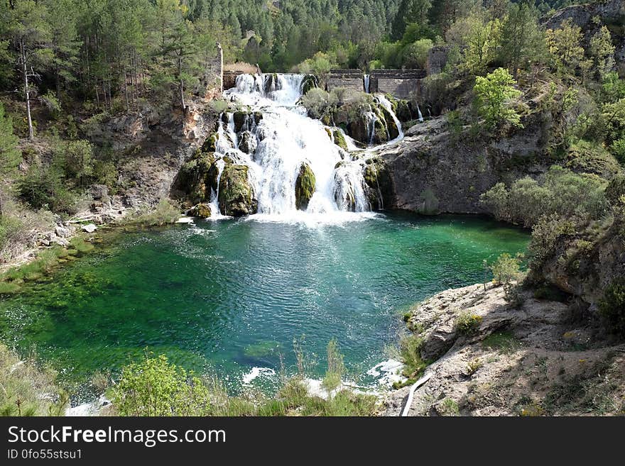 A cascading waterfall pouring into a lake. A cascading waterfall pouring into a lake.