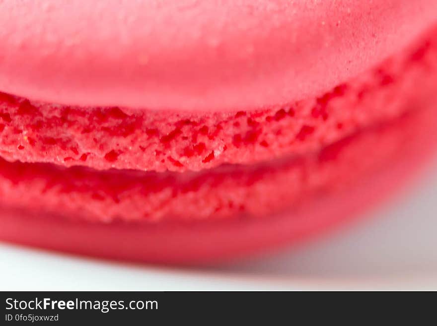 A close up of a red macaron cookie.