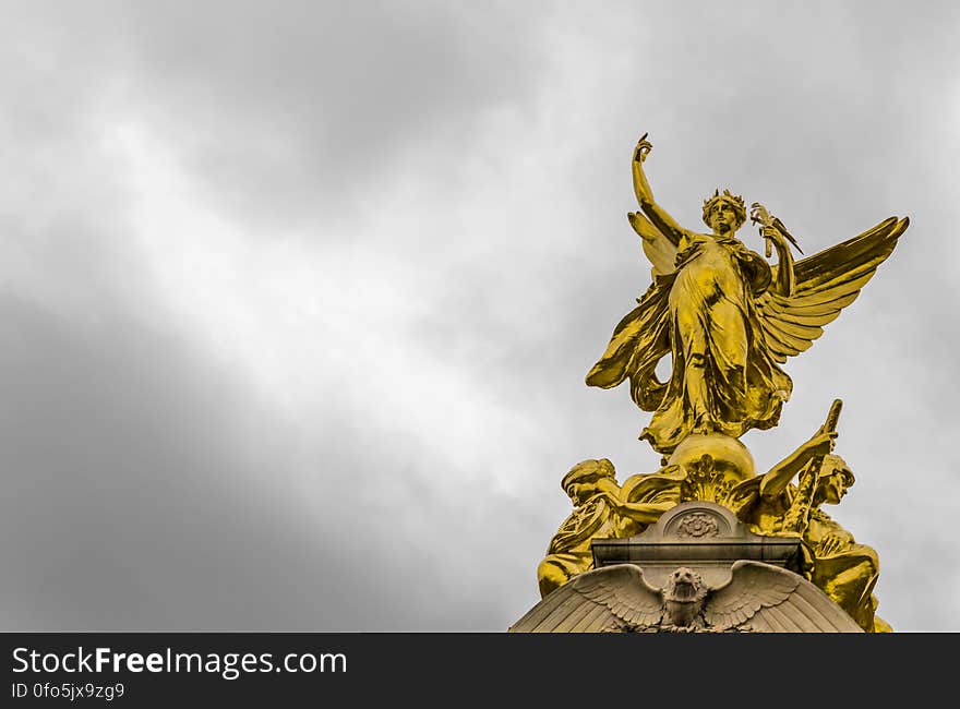 Gold Angel Statue Under Grey Clouds