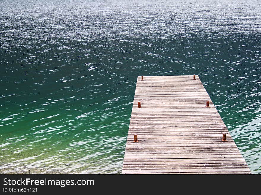 A wooden jetty leading to the waters of a lake or sea. A wooden jetty leading to the waters of a lake or sea.