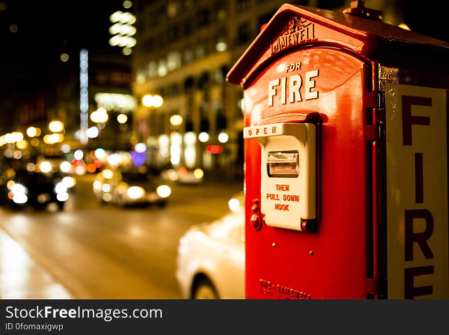 A vintage fire box in the city at night.