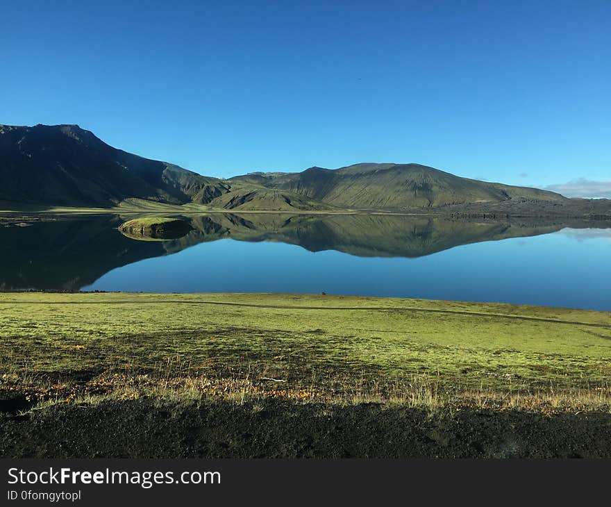 A lake and mountains reflecting on its surface.