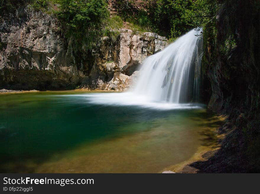 This large, natural waterfall on Fossil Creek is the destination of an easy, one mile hike on Waterfall Trail. A large, deep pool at the base of the fall is a popular swimming hole. Fossil Creek produces 20,000 gallons of water a minute from a series of springs at the bottom of a 1,600 foot deep canyon. This permanent water source has created a stunningly beautiful, green riparian zone rich with flora and fauna at the bottom of this arid canyon in Arizona&#x27;s high desert. Travertine deposits encase whatever happens to fall into the streambed, forming the fossils for which the area is named. These deposits create deep pools along the length of the creek, providing opportunities to find more secluded swimming holes than the popular pool at the waterfall. Fossil Creek is one of two &quot;Wild and Scenic&quot; rivers in Arizona. This designation was achieved when the Irving power plant was decommissioned, and removal of flume and dam on the creek allowed the creek to flow free. Increasing popularity has led to the Coconino and Tonto National Forests to implement a parking permit reservation system in 2016. Reserved parking permits allow visitors to have a parking spot available in their chosen parking lot. Many visitors drive two or three hours to get to the creek. The final descent to the creek at the bottom of a canyon is on an extremely rough, rocky jeep road. In prior years, the area would often be closed to entry when it reached capacity, and potential visitors would be turned away after the long, difficult drive. Photo by Deborah Lee Soltesz, May 12, 2016. For trail and recreation information, see Fossil Creek, Fossil Springs Wilderness, and the Coconino National Forest. This large, natural waterfall on Fossil Creek is the destination of an easy, one mile hike on Waterfall Trail. A large, deep pool at the base of the fall is a popular swimming hole. Fossil Creek produces 20,000 gallons of water a minute from a series of springs at the bottom of a 1,600 foot deep canyon. This permanent water source has created a stunningly beautiful, green riparian zone rich with flora and fauna at the bottom of this arid canyon in Arizona&#x27;s high desert. Travertine deposits encase whatever happens to fall into the streambed, forming the fossils for which the area is named. These deposits create deep pools along the length of the creek, providing opportunities to find more secluded swimming holes than the popular pool at the waterfall. Fossil Creek is one of two &quot;Wild and Scenic&quot; rivers in Arizona. This designation was achieved when the Irving power plant was decommissioned, and removal of flume and dam on the creek allowed the creek to flow free. Increasing popularity has led to the Coconino and Tonto National Forests to implement a parking permit reservation system in 2016. Reserved parking permits allow visitors to have a parking spot available in their chosen parking lot. Many visitors drive two or three hours to get to the creek. The final descent to the creek at the bottom of a canyon is on an extremely rough, rocky jeep road. In prior years, the area would often be closed to entry when it reached capacity, and potential visitors would be turned away after the long, difficult drive. Photo by Deborah Lee Soltesz, May 12, 2016. For trail and recreation information, see Fossil Creek, Fossil Springs Wilderness, and the Coconino National Forest.