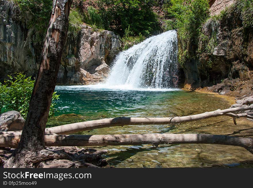 This large, natural waterfall on Fossil Creek is the destination of an easy, one mile hike on Waterfall Trail. A large, deep pool at the base of the fall is a popular swimming hole. Fossil Creek produces 20,000 gallons of water a minute from a series of springs at the bottom of a 1,600 foot deep canyon. This permanent water source has created a stunningly beautiful, green riparian zone rich with flora and fauna at the bottom of this arid canyon in Arizona&#x27;s high desert. Travertine deposits encase whatever happens to fall into the streambed, forming the fossils for which the area is named. These deposits create deep pools along the length of the creek, providing opportunities to find more secluded swimming holes than the popular pool at the waterfall. Fossil Creek is one of two &quot;Wild and Scenic&quot; rivers in Arizona. This designation was achieved when the Irving power plant was decommissioned, and removal of flume and dam on the creek allowed the creek to flow free. Increasing popularity has led to the Coconino and Tonto National Forests to implement a parking permit reservation system in 2016. Reserved parking permits allow visitors to have a parking spot available in their chosen parking lot. Many visitors drive two or three hours to get to the creek. The final descent to the creek at the bottom of a canyon is on an extremely rough, rocky jeep road. In prior years, the area would often be closed to entry when it reached capacity, and potential visitors would be turned away after the long, difficult drive. Photo by Deborah Lee Soltesz, May 12, 2016. For trail and recreation information, see Fossil Creek, Fossil Springs Wilderness, and the Coconino National Forest. This large, natural waterfall on Fossil Creek is the destination of an easy, one mile hike on Waterfall Trail. A large, deep pool at the base of the fall is a popular swimming hole. Fossil Creek produces 20,000 gallons of water a minute from a series of springs at the bottom of a 1,600 foot deep canyon. This permanent water source has created a stunningly beautiful, green riparian zone rich with flora and fauna at the bottom of this arid canyon in Arizona&#x27;s high desert. Travertine deposits encase whatever happens to fall into the streambed, forming the fossils for which the area is named. These deposits create deep pools along the length of the creek, providing opportunities to find more secluded swimming holes than the popular pool at the waterfall. Fossil Creek is one of two &quot;Wild and Scenic&quot; rivers in Arizona. This designation was achieved when the Irving power plant was decommissioned, and removal of flume and dam on the creek allowed the creek to flow free. Increasing popularity has led to the Coconino and Tonto National Forests to implement a parking permit reservation system in 2016. Reserved parking permits allow visitors to have a parking spot available in their chosen parking lot. Many visitors drive two or three hours to get to the creek. The final descent to the creek at the bottom of a canyon is on an extremely rough, rocky jeep road. In prior years, the area would often be closed to entry when it reached capacity, and potential visitors would be turned away after the long, difficult drive. Photo by Deborah Lee Soltesz, May 12, 2016. For trail and recreation information, see Fossil Creek, Fossil Springs Wilderness, and the Coconino National Forest.