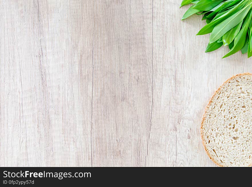 Leek and a slice of bread on a wooden surface. Leek and a slice of bread on a wooden surface.