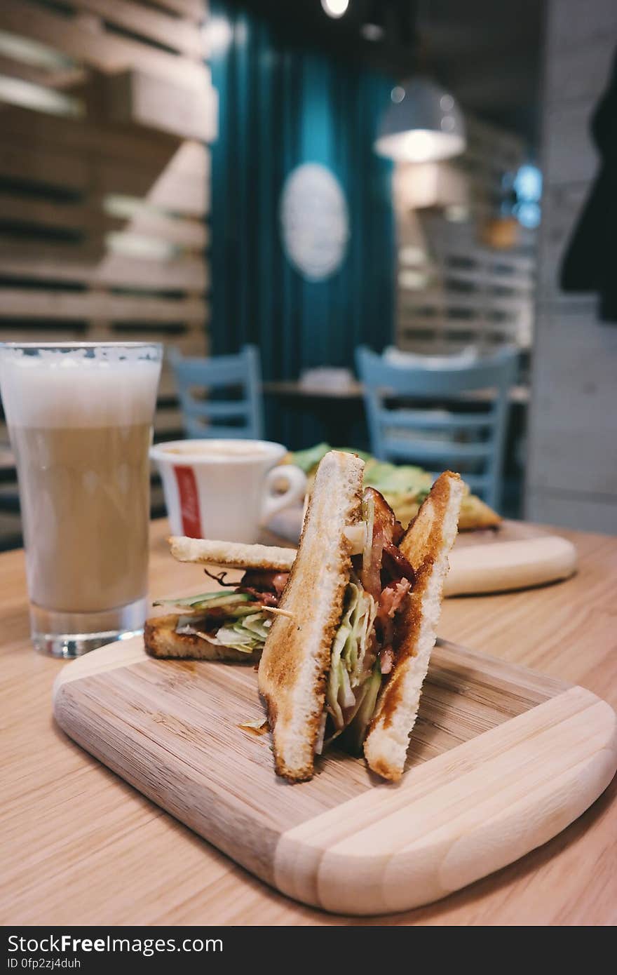 A close up of toast sandwiches and beer on a table in a cafe. A close up of toast sandwiches and beer on a table in a cafe.